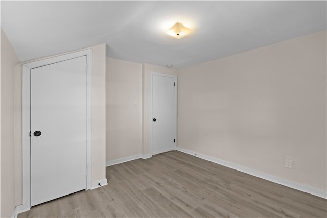 unfurnished bedroom with a closet and light hardwood / wood-style flooring