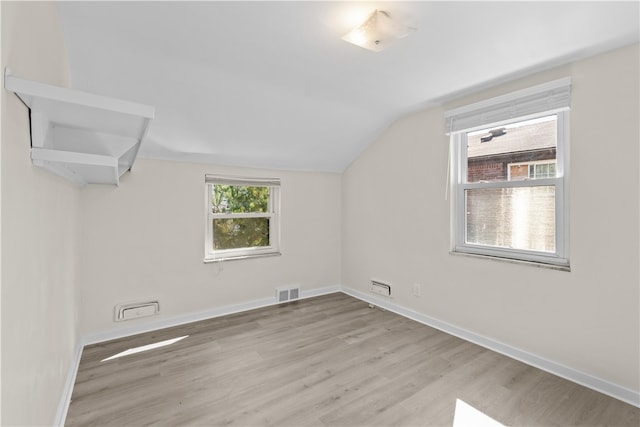 additional living space with light wood-type flooring and lofted ceiling