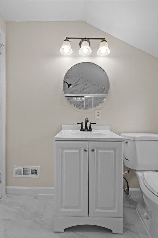 bathroom featuring lofted ceiling, toilet, and vanity