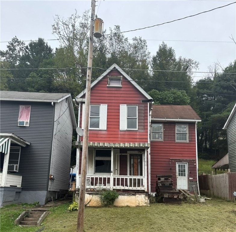 back of property featuring a lawn and a porch