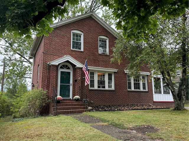 view of front of property with cooling unit and a front yard