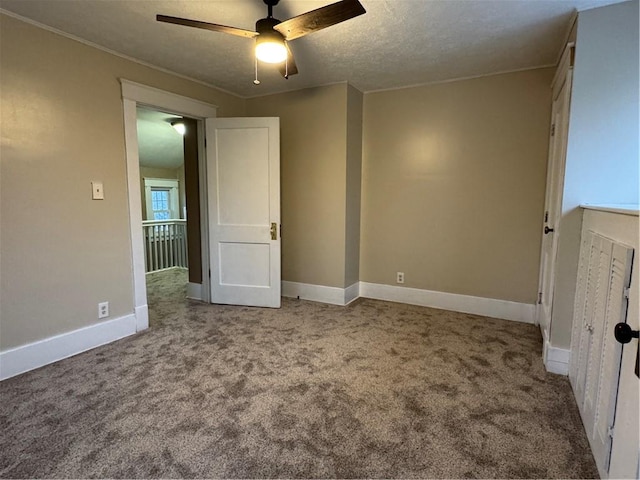 carpeted empty room featuring ceiling fan and a textured ceiling