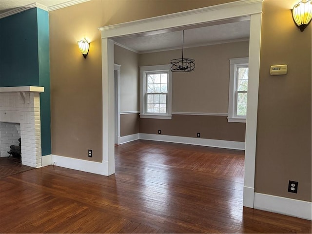 unfurnished dining area featuring a fireplace, a wealth of natural light, and crown molding