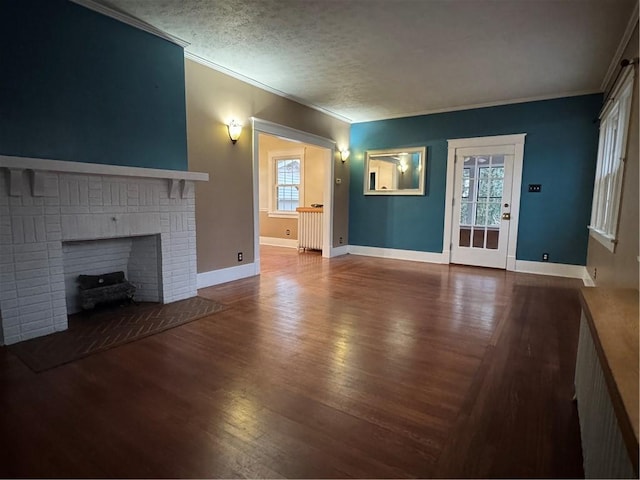 unfurnished living room with hardwood / wood-style flooring, a fireplace, crown molding, and a textured ceiling