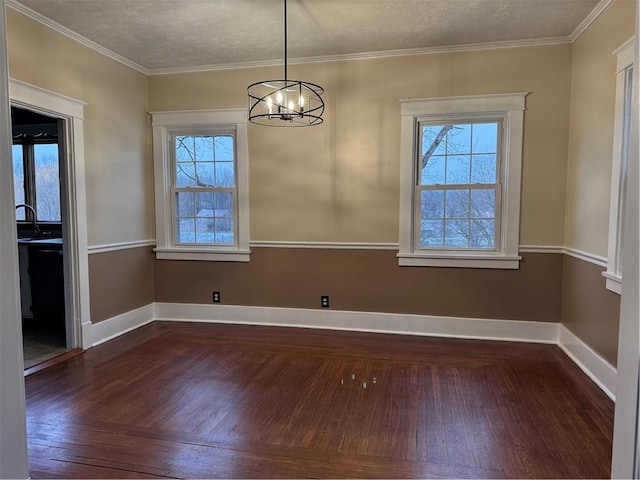 unfurnished dining area with ornamental molding, a healthy amount of sunlight, a textured ceiling, and a notable chandelier