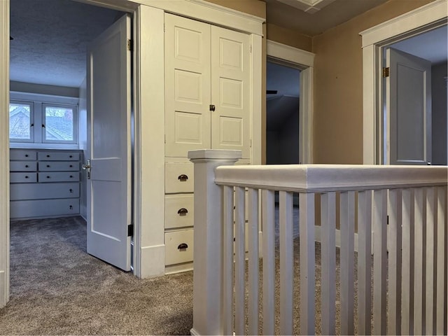 hall with dark colored carpet