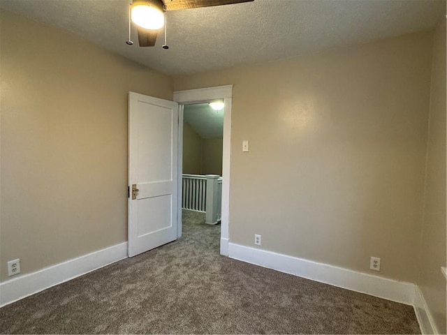 carpeted spare room featuring a textured ceiling and ceiling fan