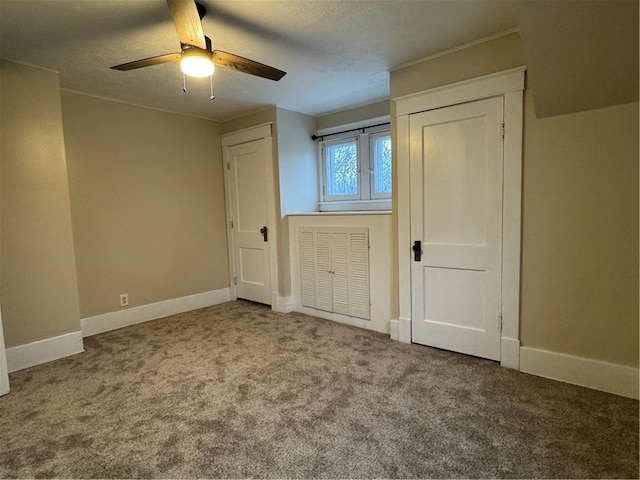 unfurnished bedroom featuring carpet flooring, ceiling fan, and a textured ceiling