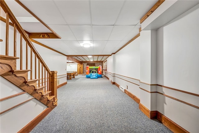 interior space featuring a paneled ceiling and carpet flooring