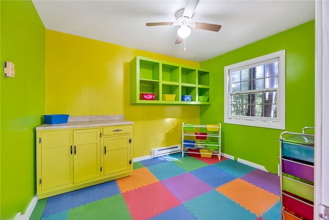 recreation room with a baseboard heating unit and ceiling fan