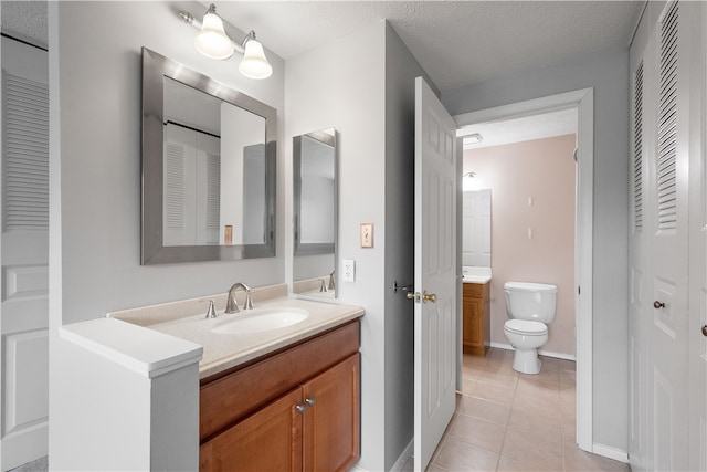 bathroom featuring tile patterned floors, a textured ceiling, vanity, and toilet