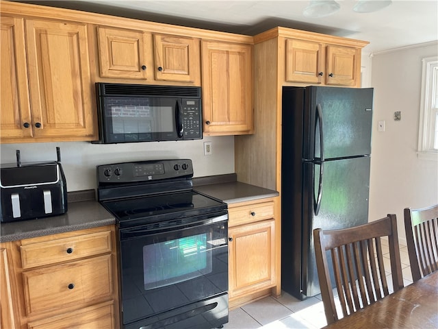 kitchen featuring light tile patterned floors and black appliances