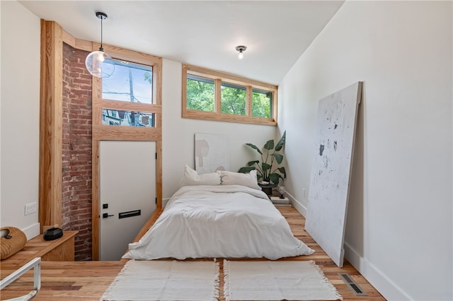 bedroom with light hardwood / wood-style floors and lofted ceiling