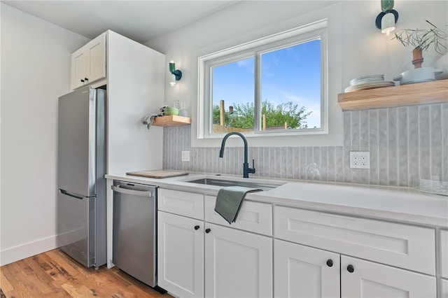 kitchen featuring sink, white cabinetry, stainless steel appliances, and light hardwood / wood-style floors