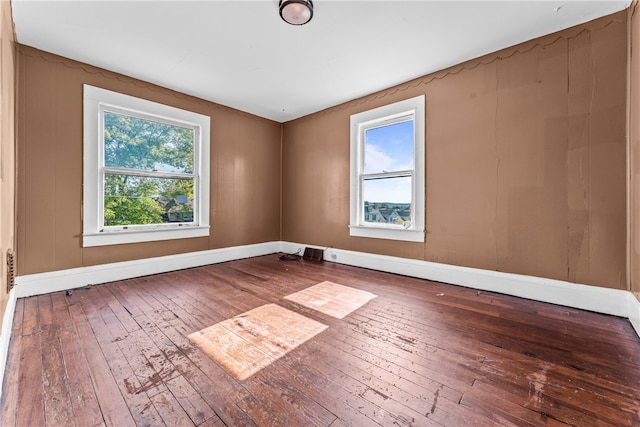 spare room with a wealth of natural light and hardwood / wood-style flooring