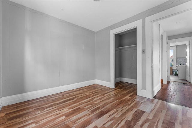 unfurnished bedroom with wood-type flooring and a closet