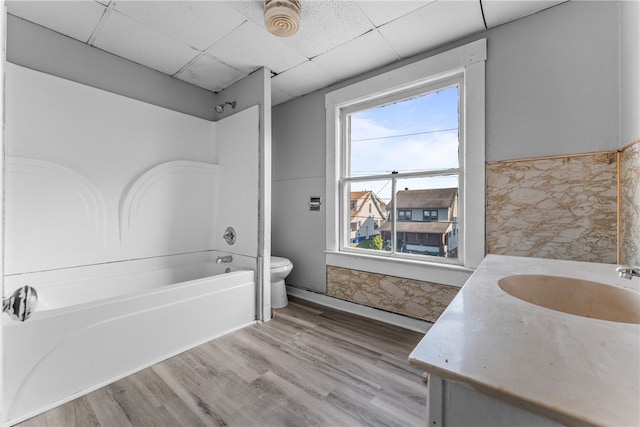 full bathroom with vanity, shower / bath combination, a paneled ceiling, tile walls, and toilet