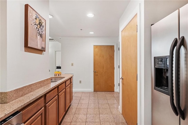 306 4th Ave Unit 501, Downtown Pgh, PA 15222 - kitchen featuring appliances with stainless steel finishes, recessed lighting, brown cabinets, light stone counters, and light tile patterned floors