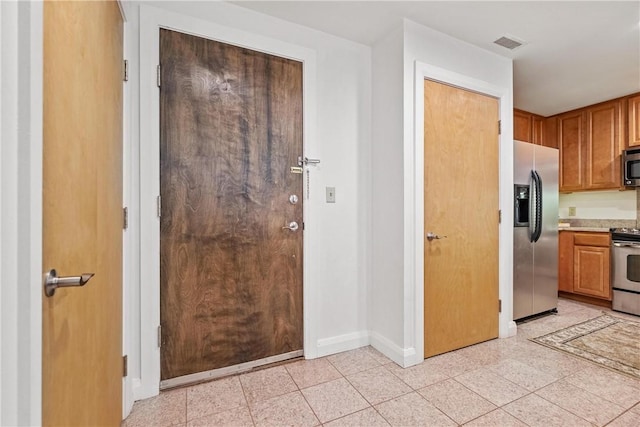 306 4th Ave Unit 501, Downtown Pgh, PA 15222 - kitchen featuring stainless steel appliances, light countertops, and brown cabinetry