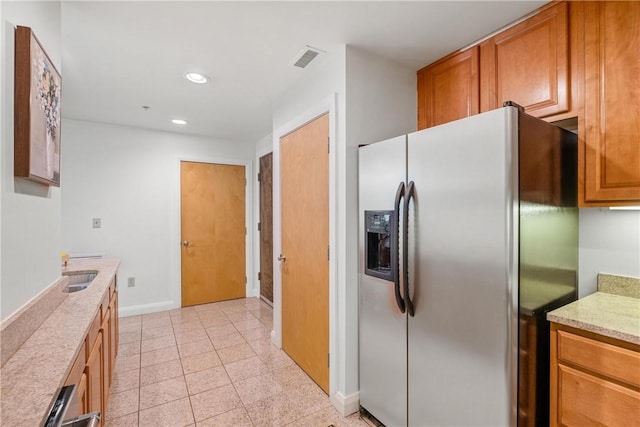 306 4th Ave Unit 501, Downtown Pgh, PA 15222 - kitchen with stainless steel fridge, recessed lighting, brown cabinets, and light stone countertops