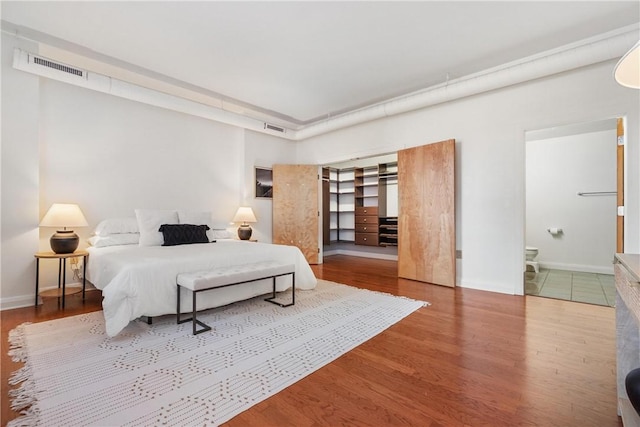 306 4th Ave Unit 501, Downtown Pgh, PA 15222 - bedroom with wood finished floors, connected bathroom, and a spacious closet