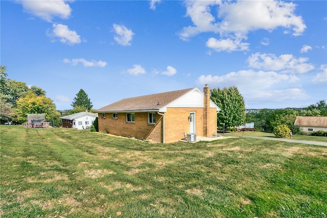 view of property exterior with central AC unit and a yard