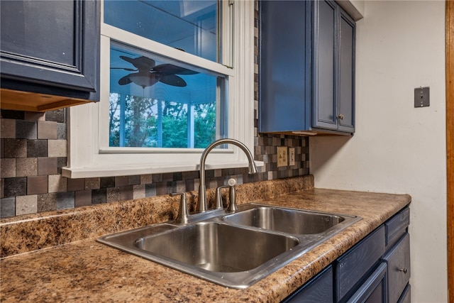 kitchen featuring decorative backsplash, blue cabinetry, and sink