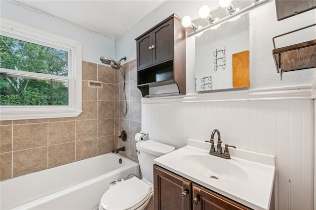 full bathroom featuring tiled shower / bath, vanity, and toilet