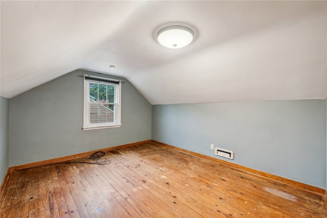 bonus room with vaulted ceiling and hardwood / wood-style flooring