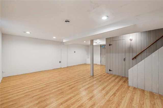 basement with light hardwood / wood-style flooring