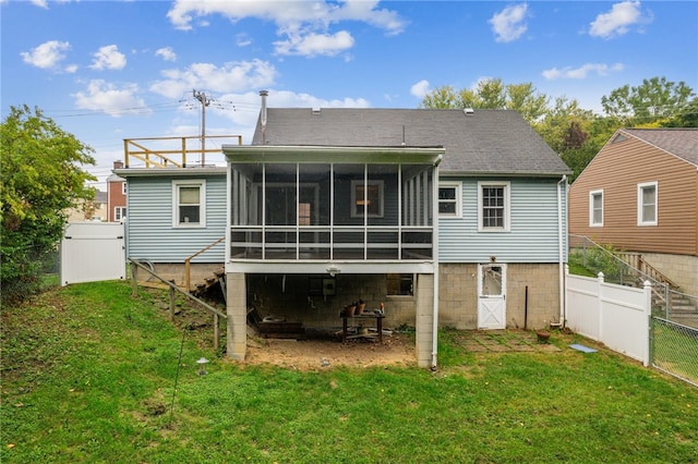 rear view of house with a sunroom and a lawn