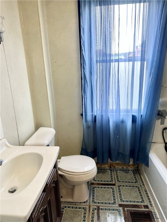 full bathroom featuring a healthy amount of sunlight, shower / tub combo, vanity, and toilet