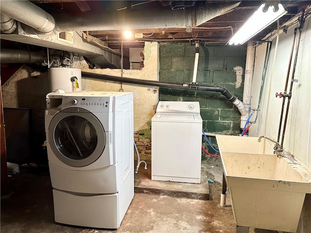 laundry area featuring washing machine and dryer, sink, and gas water heater