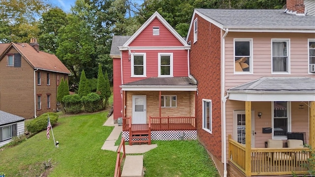 rear view of house with a deck and a yard