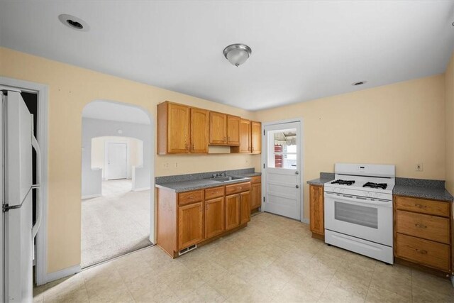 kitchen featuring light carpet and white appliances