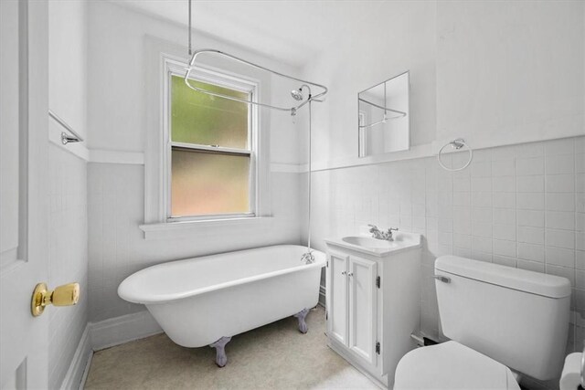 bathroom featuring tile walls, vanity, and toilet