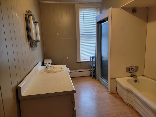 bathroom with vanity, a baseboard radiator, wood-type flooring, wooden walls, and shower with separate bathtub