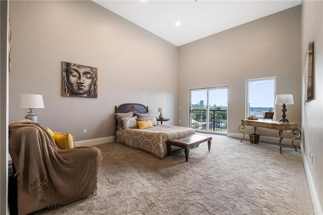 carpeted bedroom with access to exterior and high vaulted ceiling