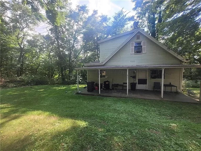 back of house featuring a patio and a yard