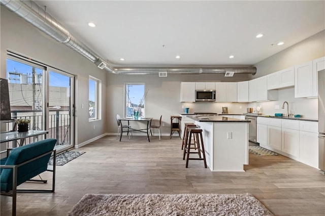 kitchen with stainless steel appliances, plenty of natural light, and white cabinets