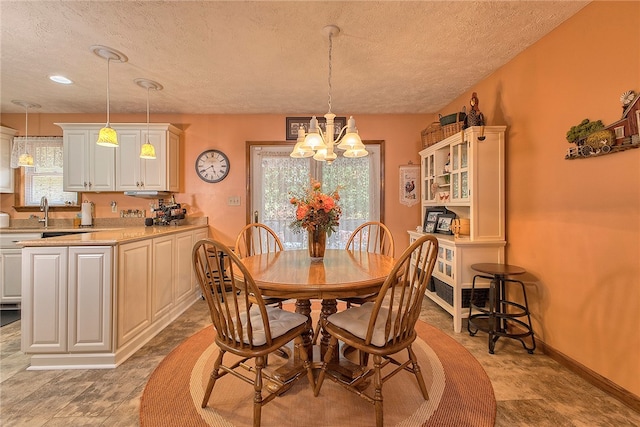 dining space featuring an inviting chandelier and a textured ceiling