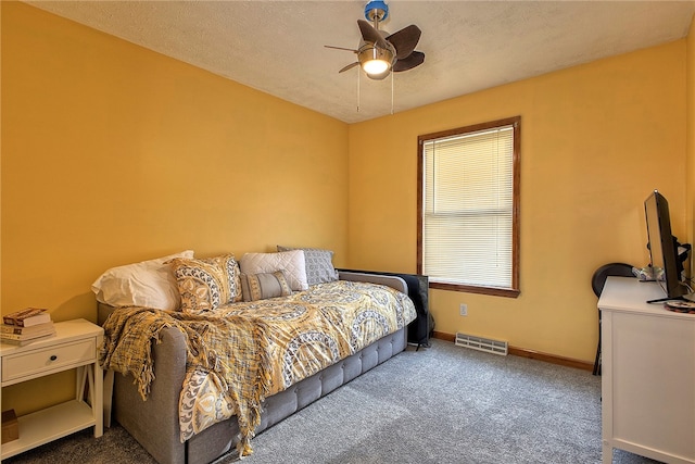 bedroom featuring ceiling fan, a textured ceiling, and carpet