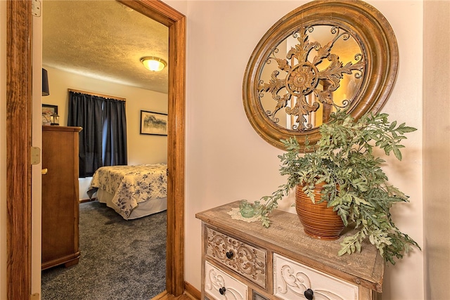 hallway featuring carpet floors and a textured ceiling