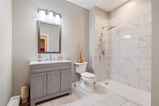 bathroom with vanity, toilet, and tiled shower