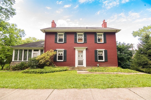 colonial-style house featuring a front yard