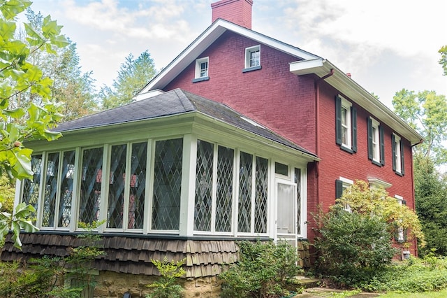 view of property exterior with a sunroom