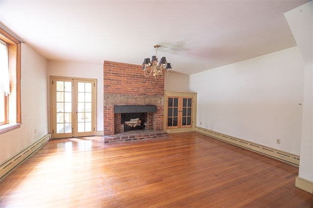 unfurnished living room featuring french doors, a fireplace, baseboard heating, and wood-type flooring