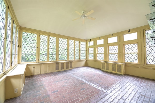 unfurnished sunroom with ceiling fan and a healthy amount of sunlight