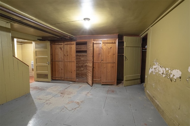 basement featuring wooden walls