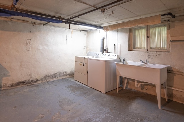 basement featuring independent washer and dryer and sink